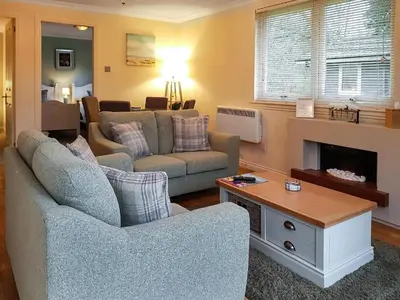 a living room with two couches and a fireplace at Loch Lomond Sanctuary Lodges in Balloch