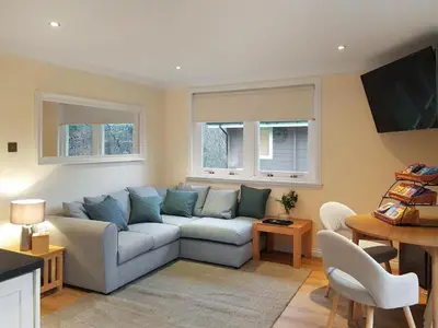 a living room with a couch and a table at Loch Lomond Sanctuary Lodges in Balloch