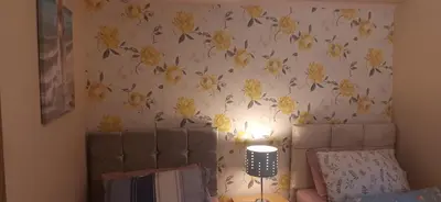 a bedroom with a wall with yellow flowers on it at Delightful home stay - Double ensuiteroom. in Glasgow