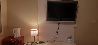 a television hanging on the corner of a room at Delightful home stay - Double ensuiteroom. in Glasgow