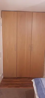 a bedroom with two large wooden cabinets next to a bed at Delightful home stay - Double ensuiteroom. in Glasgow