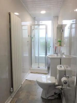 a white bathroom with a shower and a toilet at Comfortable 4 bed Apt in Paisley Next to Station in Paisley
