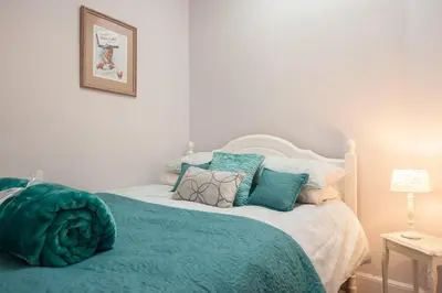 a bedroom with a bed with blue pillows at The Distillers Den in Oban