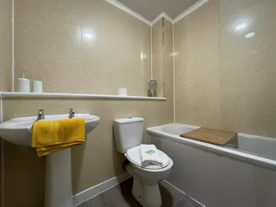 a bathroom with a toilet and a sink and a bath tub at Dunbeth House in Coatbridge