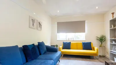 a living room with a blue couch and a yellow bench at The Riverside in Alloa