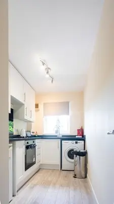 a kitchen with white cabinets and a dishwasher at The Riverside in Alloa