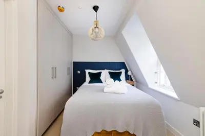 a bedroom with a white bed with blue accents at JOIVY Tasteful Studios on Rose South in Edinburgh