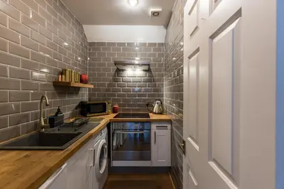 a small kitchen with a sink and a microwave at JOIVY Contemporary Cottage with Free Parking in Edinburgh