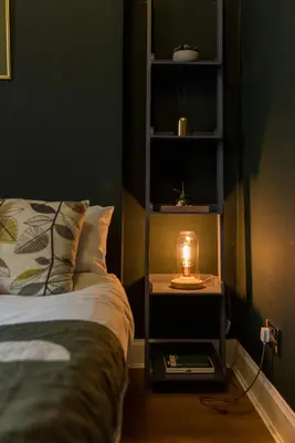 a candle on a night stand next to a bed at JOIVY Contemporary Cottage with Free Parking in Edinburgh