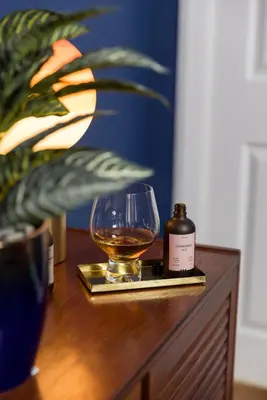 a glass of whiskey and a bottle on a tray at JOIVY Contemporary Cottage with Free Parking in Edinburgh