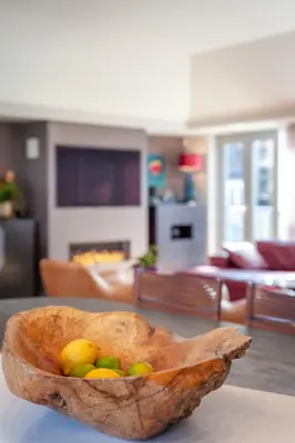 a wooden bowl of fruit on a table in a living room at JOIVY Beautiful Penthouse with Terrace & Jacuzzi in Edinburgh