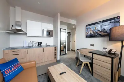 a living room with a kitchen and a dining room at Sandman Signature Glasgow Hotel in Glasgow