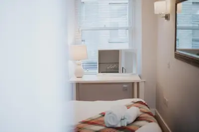 a bedroom with a bed with towels and a tv at Luxury Modern 3 Bedroom Apartment in City Centre in Edinburgh