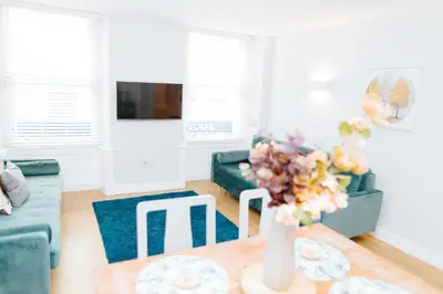 a living room with a vase of flowers on a table at Luxury Modern 3 Bedroom Apartment in City Centre in Edinburgh