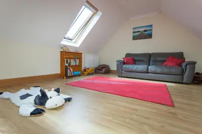 a living room with a dog laying on the floor at Honeysuckle Cottage at Williamscraig Holiday Cottages in Linlithgow