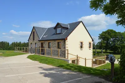 a house with a black roof at The Farmhouse at Williamscraig Holiday Cottages in Linlithgow