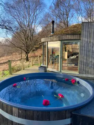 a hot tub in a backyard with a house at Craigmaddie Muir Roundhouse with Hot Tub Romantic, Luxury, Rural Stay for 2 Near Milngavie in Glasgow