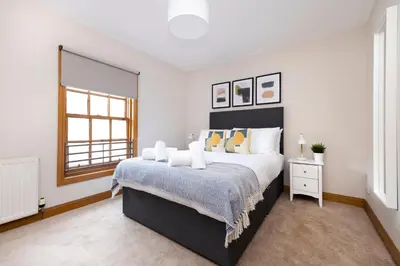 a bedroom with a large bed and a window at JOIVY Bright and Cosy Flat near The Scotland Gallery in Edinburgh