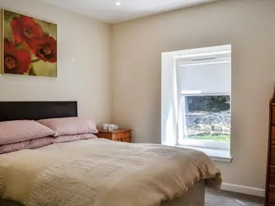 a bedroom with a bed and a window at Holly - Apartment in Aberfoyle