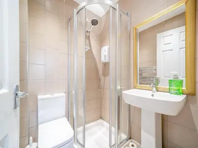 a bathroom with a shower and a sink and a toilet at Charles House in Largs