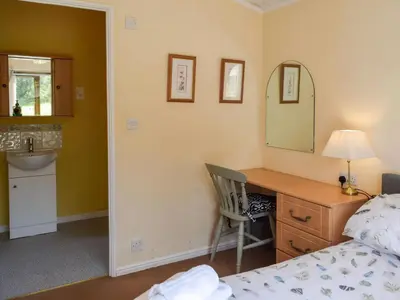 a bedroom with a bed and a desk with a mirror at Teasel Lodge - Uk39647 in Lunga