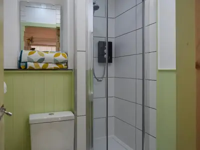 a bathroom with a toilet and a glass shower at Daisybank Cottage in Crieff
