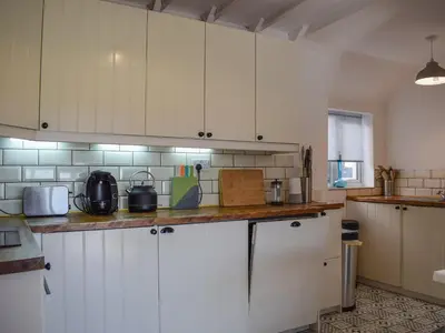 a kitchen with white cabinets and a counter top at Daisybank Cottage in Crieff