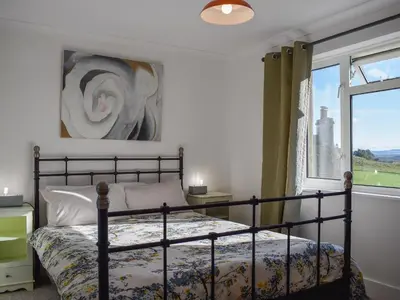 a bedroom with a bed and a window at Daisybank Cottage in Crieff