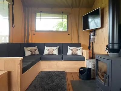 a living room with a couch and a tv at Ecosse Glamping in Crossford