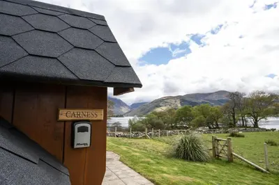 a sign on the side of a house with a phone at Leven View Lodges - Carness in Fort William