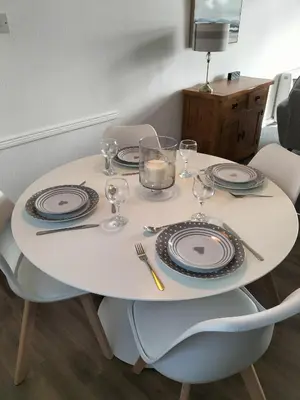 a white table with plates and glasses on it at Seaview cosy 2 bed home in Lamlash - 'Mid Drive' in Lamlash