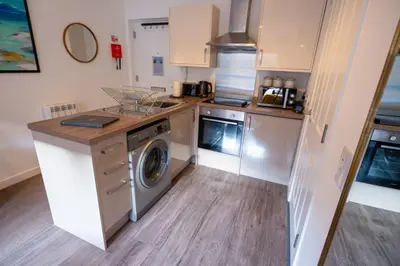 a kitchen with a washer and dryer in it at Springbank Apartment in Oban