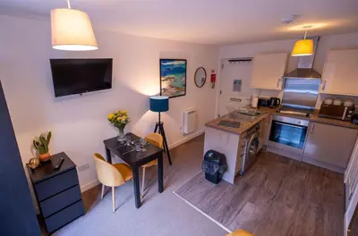 a small kitchen with a table and a counter top at Talisker Apartrment in Oban