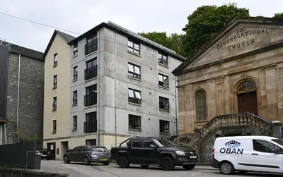 a white van parked in front of a building at Talisker Apartrment in Oban