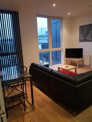 a living room with a black couch and a television at Modern 2BD2Bath Apart CityCentre in Glasgow