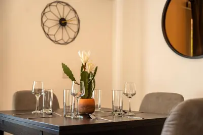 a table with wine glasses and a plant on it at Lagavulin Apartment in Oban