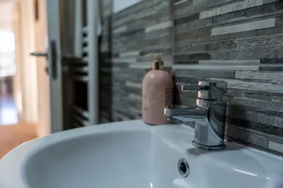 a bathroom sink with a soap dispenser on top of it at Ledaig Apartment in Oban