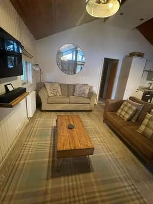 a living room with a couch and a coffee table at Bell Rock Holiday Lodge in Killin