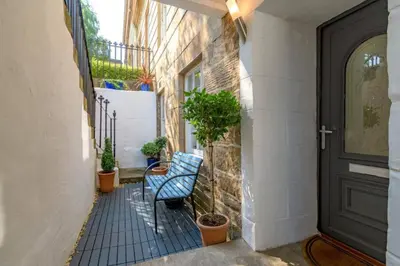 a hallway with a blue bench and a black door at Lovely 2 Bedroom Garden Flat in trendy West End in Glasgow