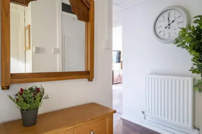 a mirror and a clock on a wall at Lovely 1-bedroom property with balcony in West end in Glasgow
