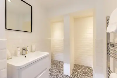 a white bathroom with a sink and a mirror at RÌGH Properties - Luxury West End Artisan Apartment in Edinburgh
