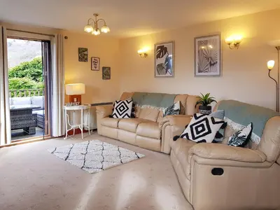 a living room with two couches and a window at The Old Post Office On Loch Tay in Stron-fearnan