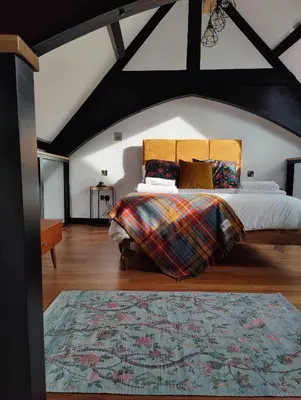 a bedroom with a king sized bed in a attic at Slateford House 1770 Luxury Aparthotel by The House of Danu in Edinburgh