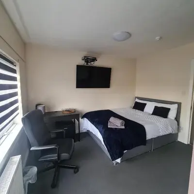 a bedroom with a bed and a desk and a chair at The Beath Inn in Cowdenbeath