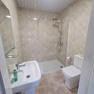 a bathroom with a shower and a toilet and a sink at The Beath Inn in Cowdenbeath