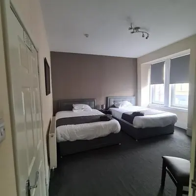 a hotel room with two beds and a window at The Beath Inn in Cowdenbeath