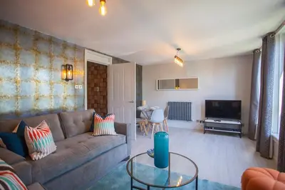 a living room with a couch and a table at Beautiful West End Flat with Private Parking in Glasgow