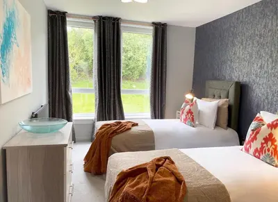 a hotel room with two beds and a window at Beautiful West End Flat with Private Parking in Glasgow