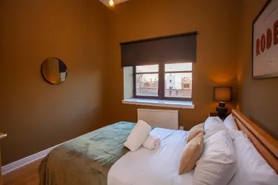 a bedroom with a bed with white pillows and a window at Glasgow Green Getaway with Free Parking in Glasgow