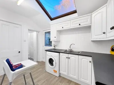 a kitchen with a sink and a washing machine at No.3 The Villa in Oban